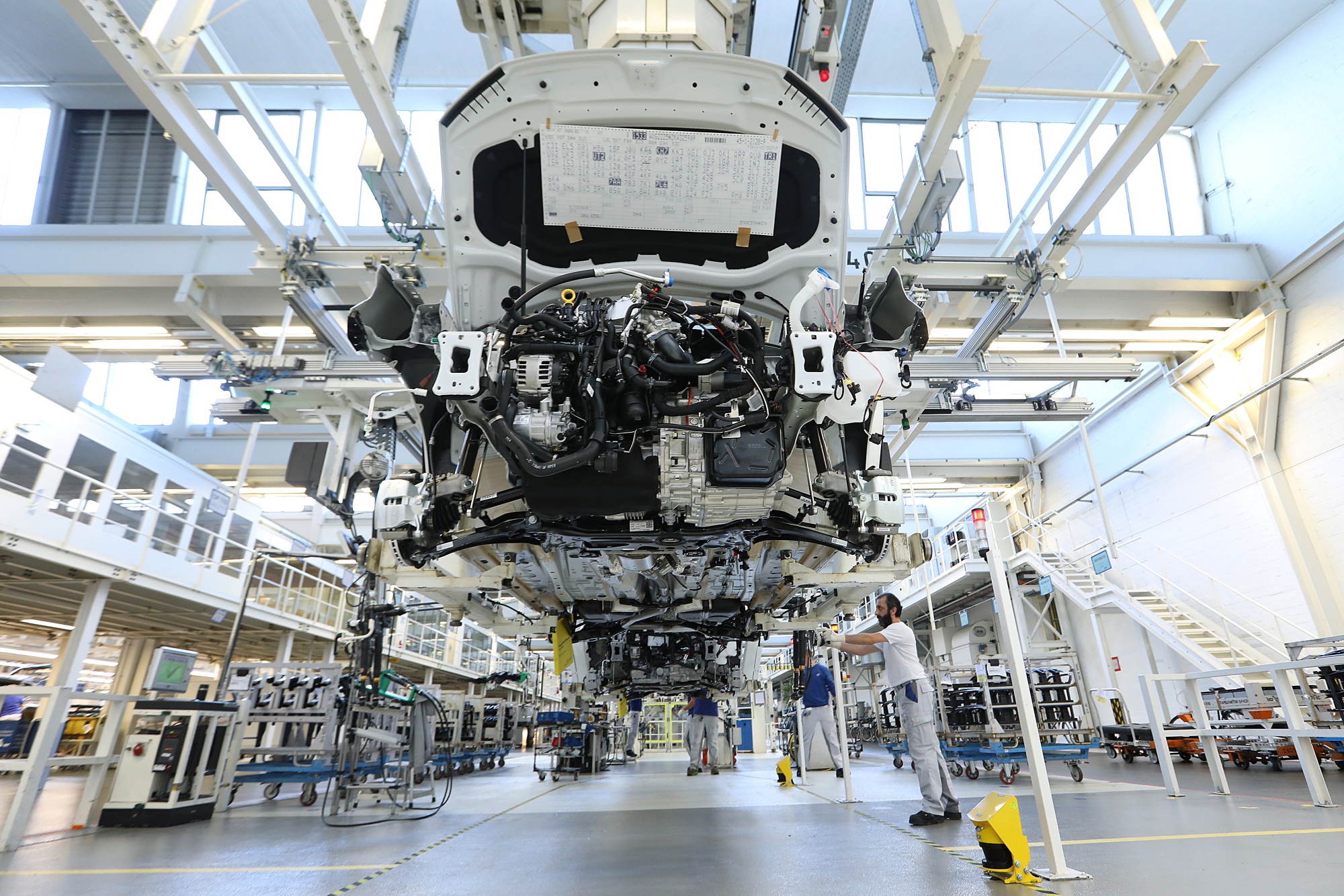 A Volkswagen Tiguan hangs from a cradle on the assembly line at the Volkswagen AG (VW) factory in Wolfsburg. Photographer: Krisztian Bocsi/Bloomberg
