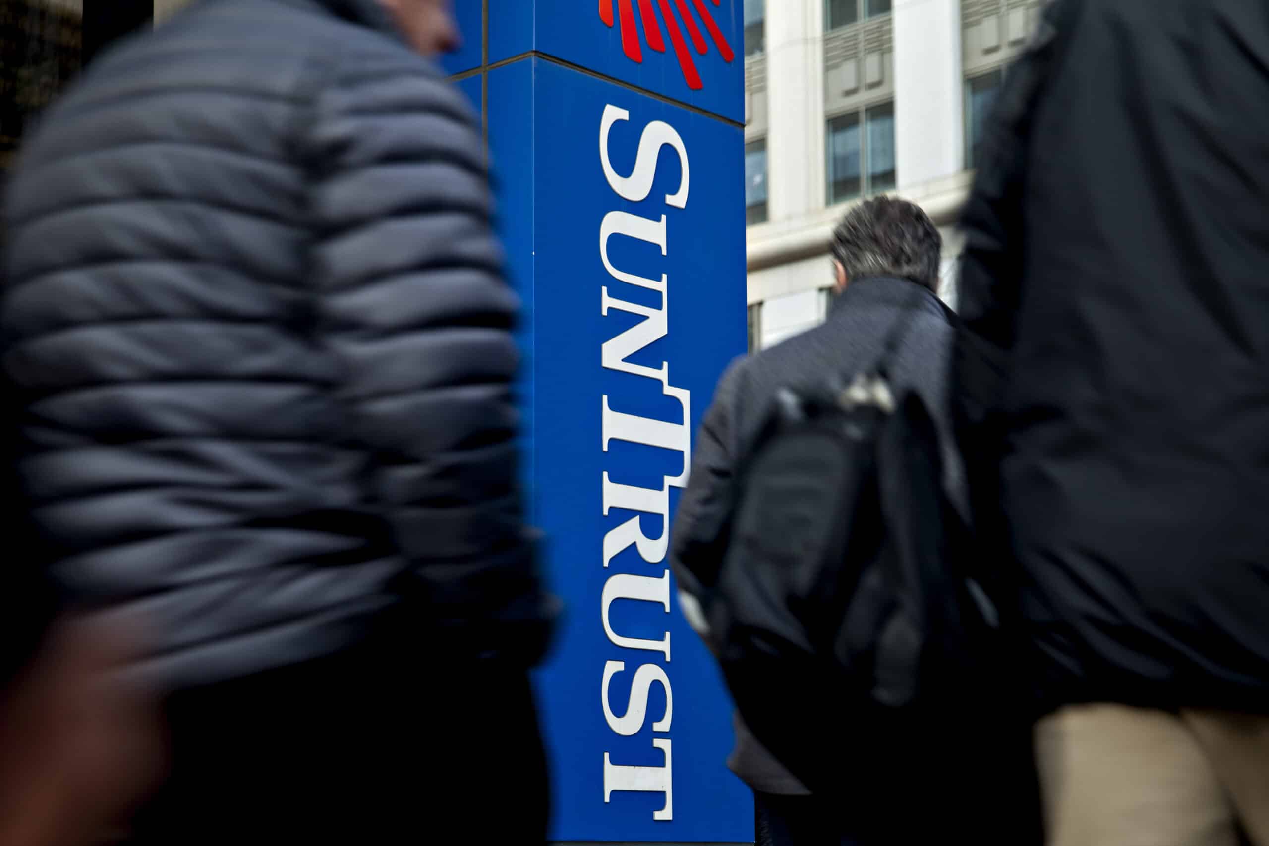 Pedestrians pass in front of a SunTrust Banks Inc. branch in Washington, D.C., U.S. Photographer: Andrew Harrer/Bloomberg