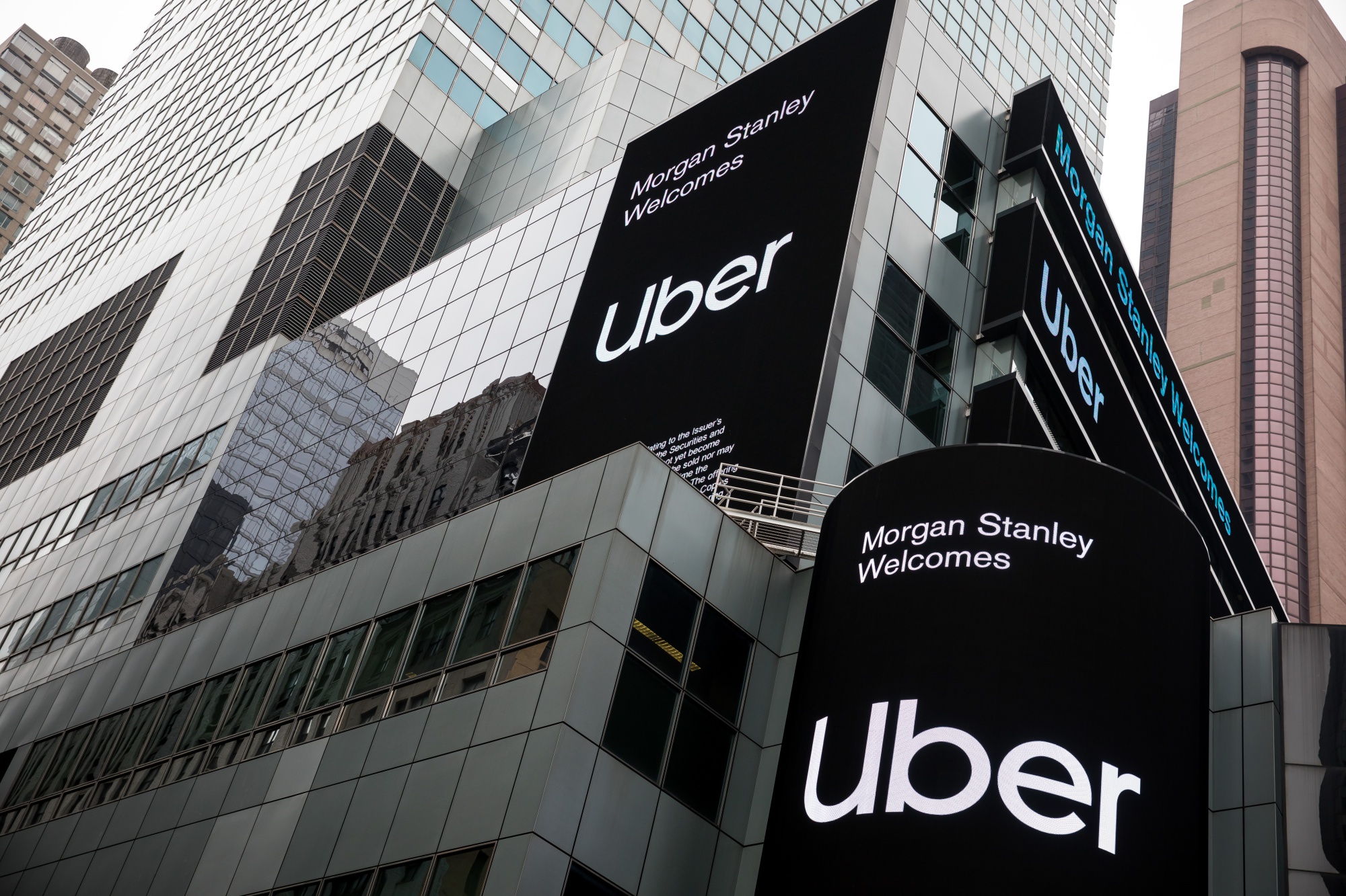 Monitors display Uber Technologies Inc. signage in front of Morgan Stanley headquarters in the Times Square area of New York, U.S., on Friday, April 26, 2019. U.S. stocks edged higher on better-than-forecast earnings while Treasury yields fell after data signaled tepid inflation in the first quarter. Photographer: Michael Nagle/Bloomberg