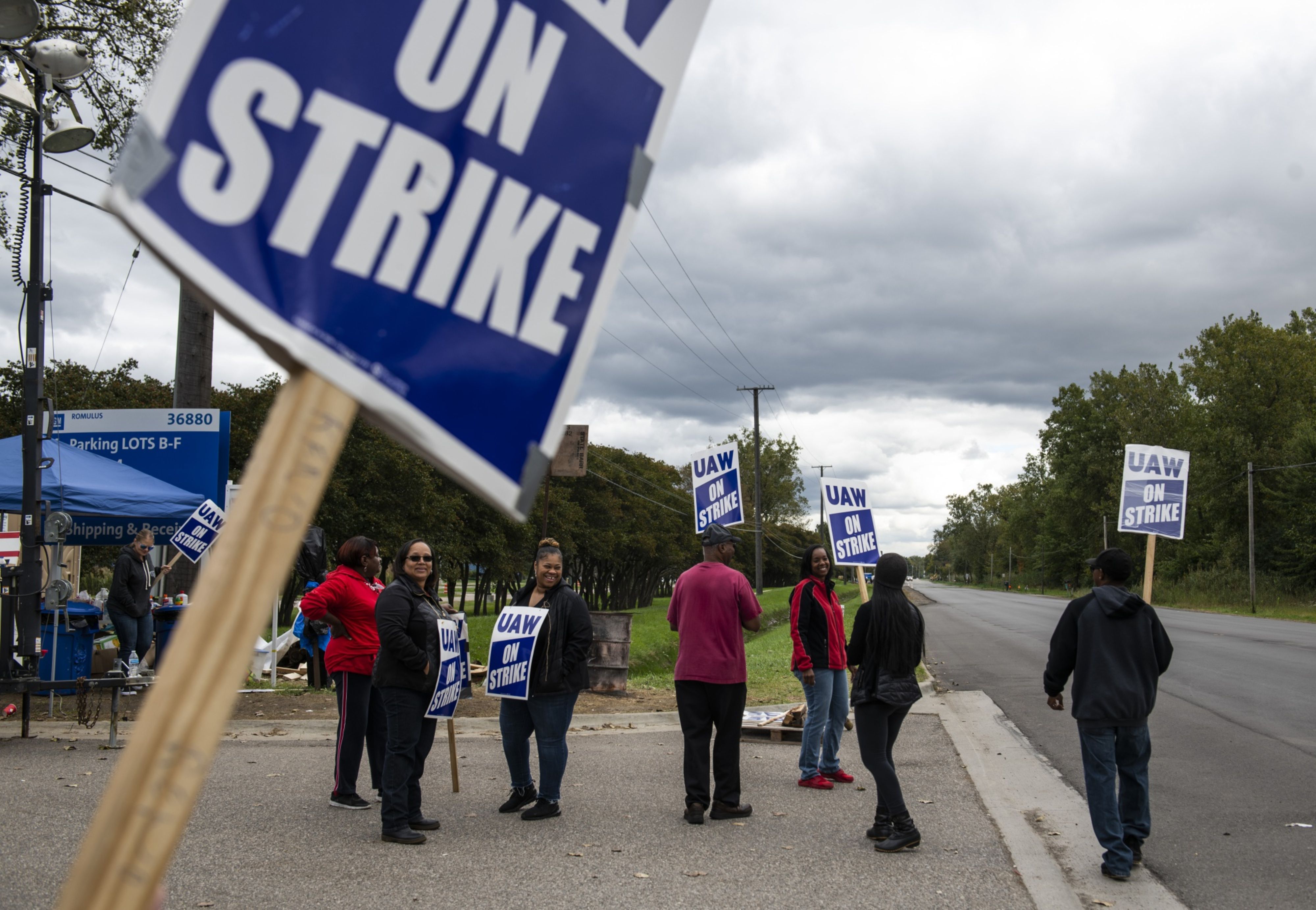 Demonstrators hold signs during a United Auto Workers (UAW) strike outside the General Motors plant in Romulus, Michigan on Friday, Oct. 4, 2019. Photographer: Brittany Greeson/Bloomberg