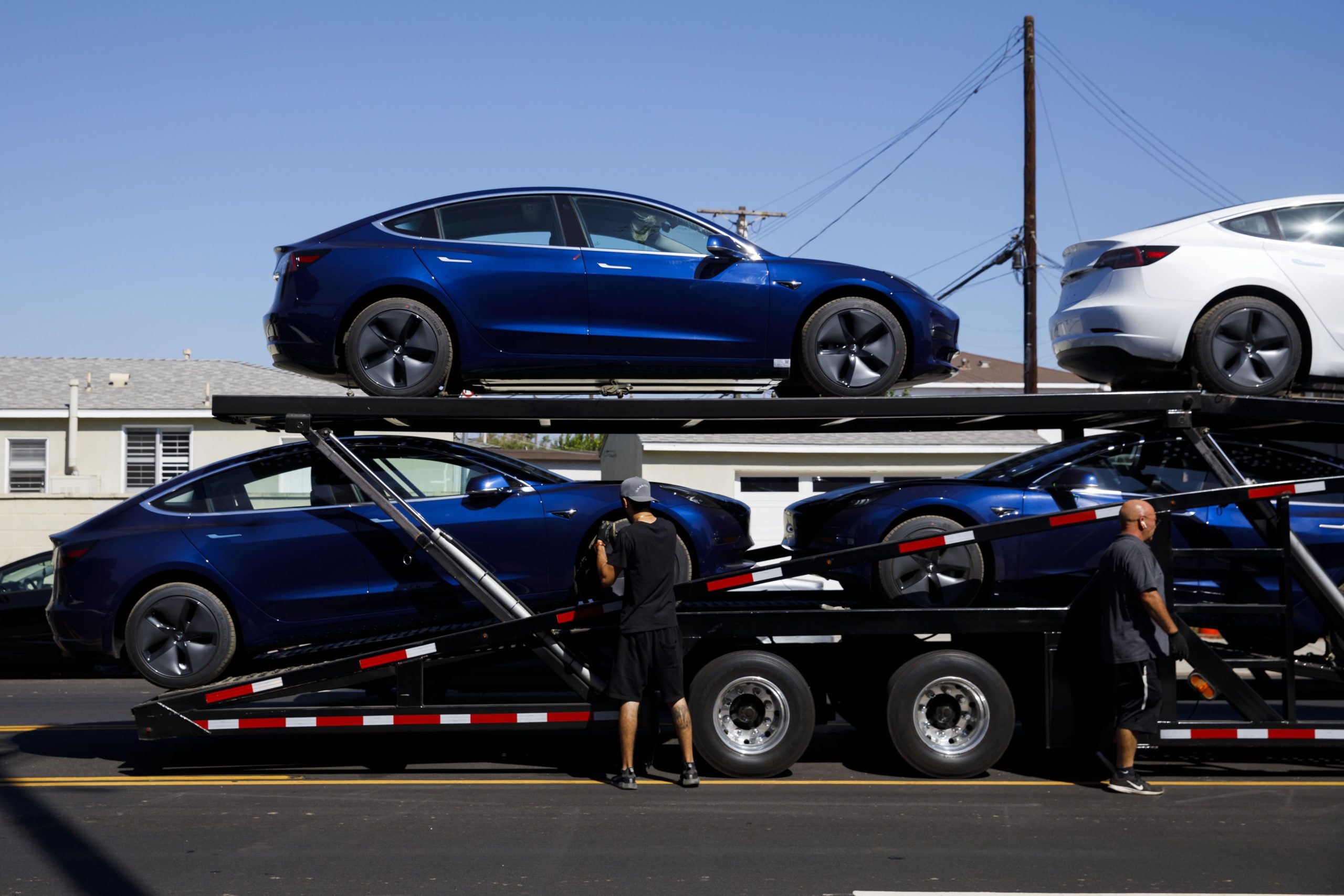 Tesla Inc. Model 3 electric vehicles are unloaded from a car carrier at the company's delivery center in Marina Del Rey, California, U.S., on Saturday, Sept. 29, 2018. Photographer: Patrick T. Fallon/Bloomberg