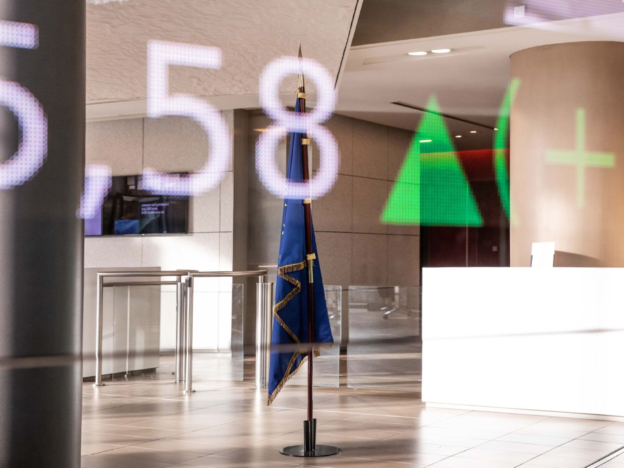Stock information is projected on a glass panel as a European Union (EU) flag hangs in the lobby of the Euronext Paris stock exchange in La Defense business district of Paris, France, on Wednesday, Jan. 16, 2019. European investors shook off the rejection of U.K. Prime Minister Theresa Mays Brexit deal in parliament ahead of a confidence vote, opening higher after mixed markets in Asia, and gains in the U.S. Photographer: Bloomberg/Bloomberg