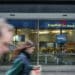 capital one atm with people moving past