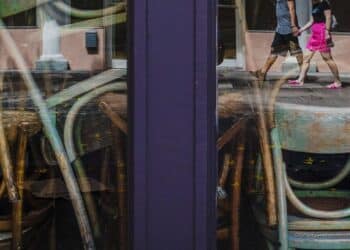 Pedestrians are reflected in the windows of a closed restaurant in the South Beach neighborhood of Miami Beach on March 20. Photographer: Scott McIntyre/Bloomberg