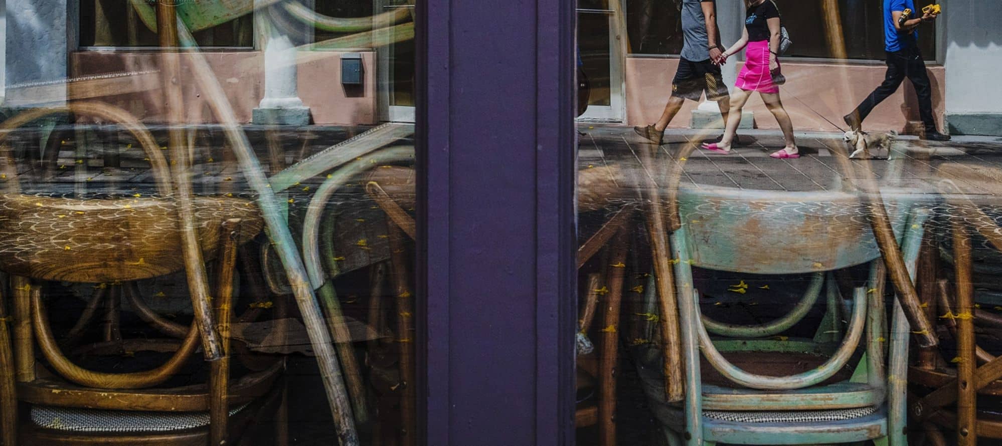 Pedestrians are reflected in the windows of a closed restaurant in the South Beach neighborhood of Miami Beach on March 20. Photographer: Scott McIntyre/Bloomberg