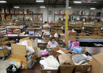 An employee wearing a protective mask works at the Gifts For You company warehouse. Photographer: Olivia Obineme/Bloomberg