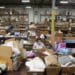 An employee wearing a protective mask works at the Gifts For You company warehouse. Photographer: Olivia Obineme/Bloomberg