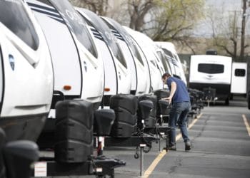 A manager inspects a row of travel trailers at Motor Sportsland RV dealership in Salt Lake City, Utah, U.S., on Monday, April 6, 2020. Amid the coronvirus, government agencies are obtaining RVs to house the homeless and provide housing for medical workers who can not return home in fear of spreading the virus.