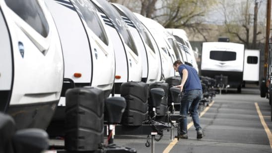 A manager inspects a row of travel trailers at Motor Sportsland RV dealership in Salt Lake City, Utah, U.S., on Monday, April 6, 2020. Amid the coronvirus, government agencies are obtaining RVs to house the homeless and provide housing for medical workers who can not return home in fear of spreading the virus.
