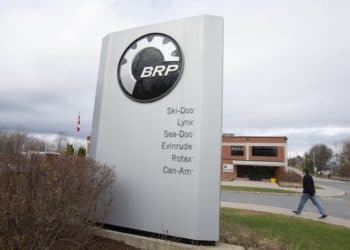A pedestrian walks past signage for a BRP manufacturing facility in Valcourt, Quebec, Canada, on Wednesday, Oct. 28, 2020. BRP Inc. says production shutdowns depleted its inventory and dragged down revenues in its second quarter, but rising demand buoyed profits as fun-seekers turned to power sports for pandemic recreation, The Toronto Star reported. Photographer: Christinne Muschi/Bloomberg