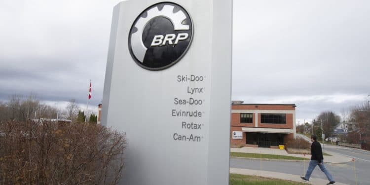 A pedestrian walks past signage for a BRP manufacturing facility in Valcourt, Quebec, Canada, on Wednesday, Oct. 28, 2020. BRP Inc. says production shutdowns depleted its inventory and dragged down revenues in its second quarter, but rising demand buoyed profits as fun-seekers turned to power sports for pandemic recreation, The Toronto Star reported.