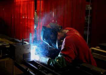 A worker welds a lawnmower frame together on the assembly line at a facility in Coatesville, Indiana. Photographer: Luke Sharrett/Bloomberg