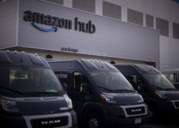 Delivery vans parked outside the package pick-up and returns area of an Amazon fulfillment center in Denver, Colorado.