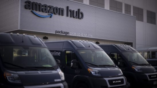 Delivery vans parked outside the package pick-up and returns area of an Amazon fulfillment center in Denver, Colorado.