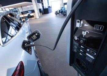 A Mercedes-Benz EQC electric vehicle connected to a charger inside a Mercedes-Benz AG showroom in Berlin, Germany