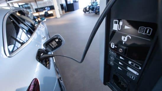 A Mercedes-Benz EQC electric vehicle connected to a charger inside a Mercedes-Benz AG showroom in Berlin, Germany