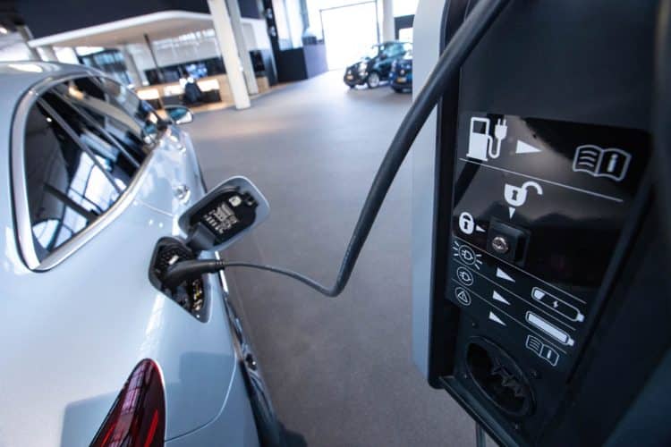 A Mercedes-Benz EQC electric vehicle connected to a charger inside a Mercedes-Benz AG showroom in Berlin, Germany