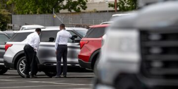 Customers view a vehicle for sale at a Ford Motor Co. dealership in Richmond, California, U.S., on Thursday, July 1, 2021. The global semiconductor shortage that hobbled auto production worldwide this year is leaving showrooms with few models to showcase just as U.S. consumers breaking free of pandemic restrictions are eager for new wheels.