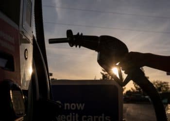 A driver holds a fuel nozzle at a gas station in Sacramento, California.