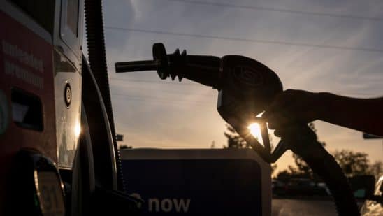 A driver holds a fuel nozzle at a gas station in Sacramento, California.