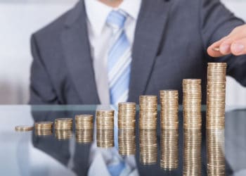 Businessperson With Stack Of Coins