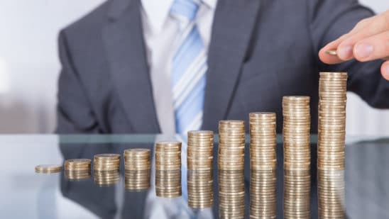 Businessperson With Stack Of Coins