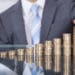 Businessperson With Stack Of Coins