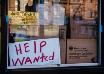 A "Help Wanted" sign outside a restaurant in the East Flatbush neighborhood in the Brooklyn borough of New York, U.S., on Monday, March 29, 2021.The U.S. economy is on a multi-speed track as minorities in some cities find themselves left behind by the overall boom in hiring, according to a Bloomberg analysis of about a dozen metro areas.