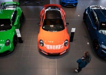 A customer looks at a Porsche GT3, left, a Porsche 911 Turbo, center, and a Porsche Taycan Turbo S automobile at a Porsche SE showroom in Berlin, Germany, on Tuesday, March 29, 2022. Porsche, which reports reports final year earnings today, delivered 301,915 vehicles to customers in 2021, an 11% jump from 2020 and the first time it has surpassed the 300,000 mark.