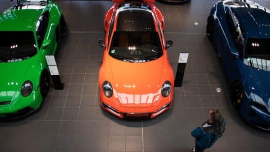 A customer looks at a Porsche GT3, left, a Porsche 911 Turbo, center, and a Porsche Taycan Turbo S automobile at a Porsche SE showroom in Berlin, Germany, on Tuesday, March 29, 2022. Porsche, which reports reports final year earnings today, delivered 301,915 vehicles to customers in 2021, an 11% jump from 2020 and the first time it has surpassed the 300,000 mark.