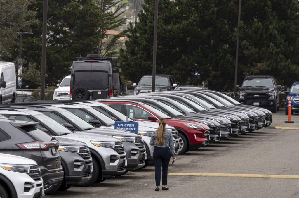 A salesperson walks on the lot of a Ford Motor Co. dealership in Colma, California, U.S., on Wednesday, June 30, 2021. With dwindling inventory over the last three months, U.S. auto sales has taken a sharp turn for the worse. Photographer: David Paul Morris/Bloomberg
