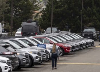 A salesperson walks on the lot of a Ford Motor Co. dealership in Colma, California, U.S., on Wednesday, June 30, 2021. With dwindling inventory over the last three months, U.S. auto sales has taken a sharp turn for the worse. Photographer: David Paul Morris/Bloomberg