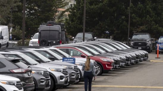 A salesperson walks on the lot of a Ford Motor Co. dealership in Colma, California, U.S., on Wednesday, June 30, 2021. With dwindling inventory over the last three months, U.S. auto sales has taken a sharp turn for the worse. Photographer: David Paul Morris/Bloomberg