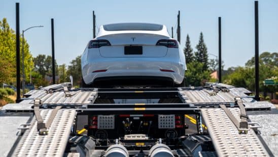 A Tesla Model 3 vehicle on an auto carrier in front of a store in Rocklin, California, U.S., on Wednesday, July 21, 2021. Tesla Inc. is scheduled to release earnings figures on July 26.