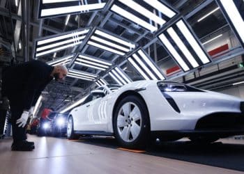 A worker checks a Porsche Taycan on the production line in Stuttgart, Germany. Photographer: Krisztian Bocsi/Bloomberg