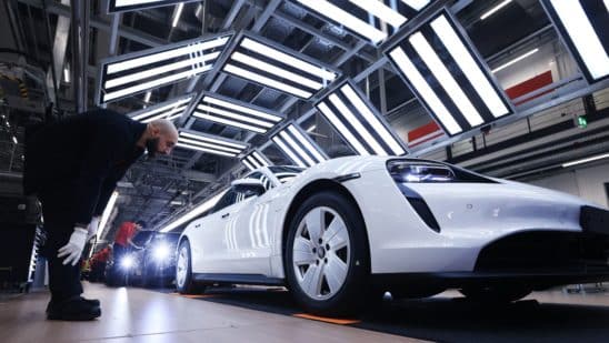 A worker checks a Porsche Taycan on the production line in Stuttgart, Germany. Photographer: Krisztian Bocsi/Bloomberg