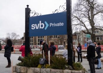 Customers stand waiting in line outside a Silicon Valley Bank branch in Wellesley, Massachusetts, US, on Monday, March 13, 2023. The collapse ofSilicon Valley Bankhas prompted aglobal reckoningat venture capital and private equity firms, which found themselves suddenly exposed all together to the tech industrys money machine.