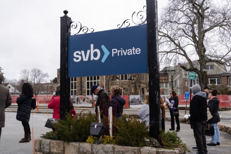 Customers stand waiting in line outside a Silicon Valley Bank branch in Wellesley, Massachusetts, US, on Monday, March 13, 2023. The collapse ofSilicon Valley Bankhas prompted aglobal reckoningat venture capital and private equity firms, which found themselves suddenly exposed all together to the tech industrys money machine.