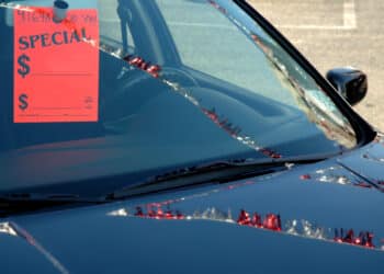 Car on a dealer lot with a tag on the mirror