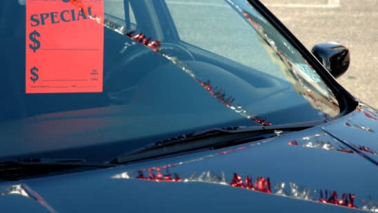 Car on a dealer lot with a tag on the mirror