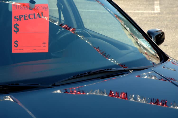 Car on a dealer lot with a tag on the mirror