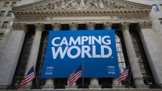 Camping World Holdings Inc. signage is displayed as American Flags fly outside of the New York Stock Exchange (NYSE) during the company's initial public offering (IPO) in New York, U.S., on Friday, Oct. 7, 2016. U.S. stocks fell after jobs data showing steady growth in the labor market likely kept the Federal Reserve on track to tighten monetary policy this year as investors turn to the third-quarter earnings season.