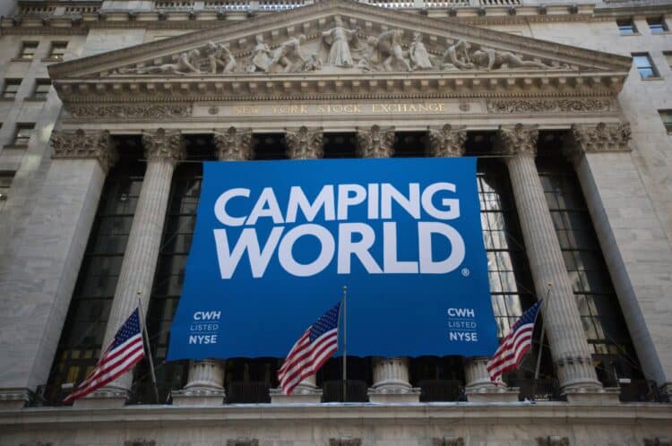 Camping World Holdings Inc. signage is displayed as American Flags fly outside of the New York Stock Exchange (NYSE) during the company's initial public offering (IPO) in New York, U.S., on Friday, Oct. 7, 2016. U.S. stocks fell after jobs data showing steady growth in the labor market likely kept the Federal Reserve on track to tighten monetary policy this year as investors turn to the third-quarter earnings season.