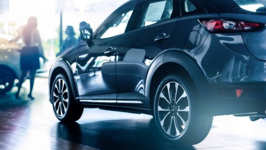 New suv car in modern luxury showroom on blur saleswoman and customer