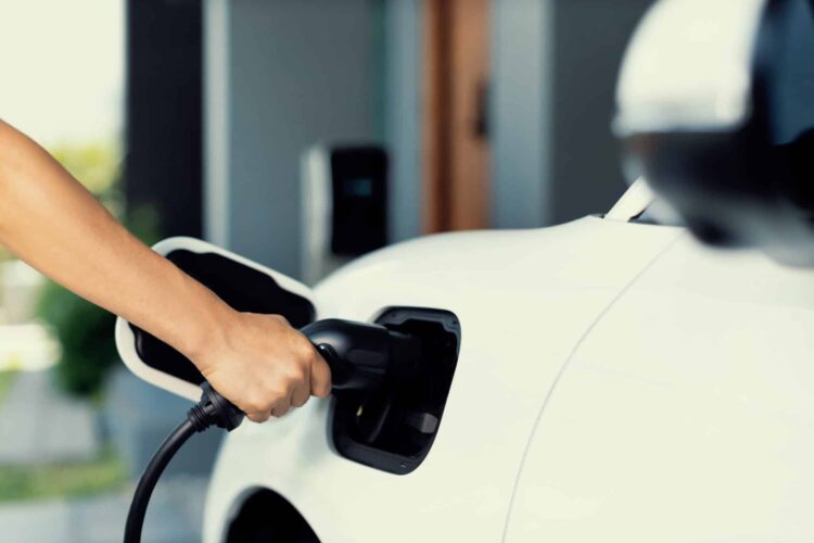 Hand insert an emission-free power connector to the battery of electric vehicle at home