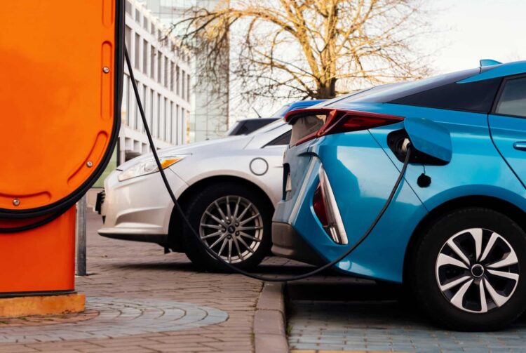Electric charging station for electric vehicles plugged into cars