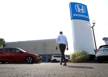 A worker walks through the lot of Paragon Honda and Acura car dealership in the Queens borough of New York, U.S., on Thursday, July 15, 2021. Soaring used-car prices accounted for more than one-third of the recent increase in the consumer price index, which in June rose at the fastest rate in 13 years.