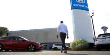 A worker walks through the lot of Paragon Honda and Acura car dealership in the Queens borough of New York, U.S., on Thursday, July 15, 2021. Soaring used-car prices accounted for more than one-third of the recent increase in the consumer price index, which in June rose at the fastest rate in 13 years.