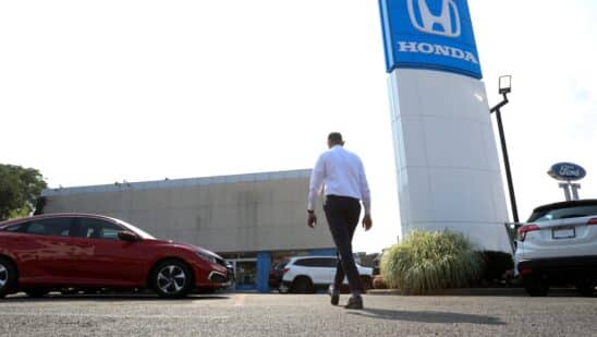 A worker walks through the lot of Paragon Honda and Acura car dealership in the Queens borough of New York, U.S., on Thursday, July 15, 2021. Soaring used-car prices accounted for more than one-third of the recent increase in the consumer price index, which in June rose at the fastest rate in 13 years.
