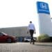 A worker walks through the lot of Paragon Honda and Acura car dealership in the Queens borough of New York, U.S., on Thursday, July 15, 2021. Soaring used-car prices accounted for more than one-third of the recent increase in the consumer price index, which in June rose at the fastest rate in 13 years.